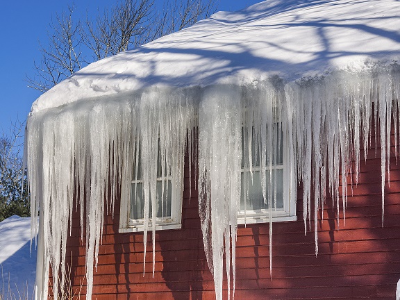 severe ice dam hanging from gutter